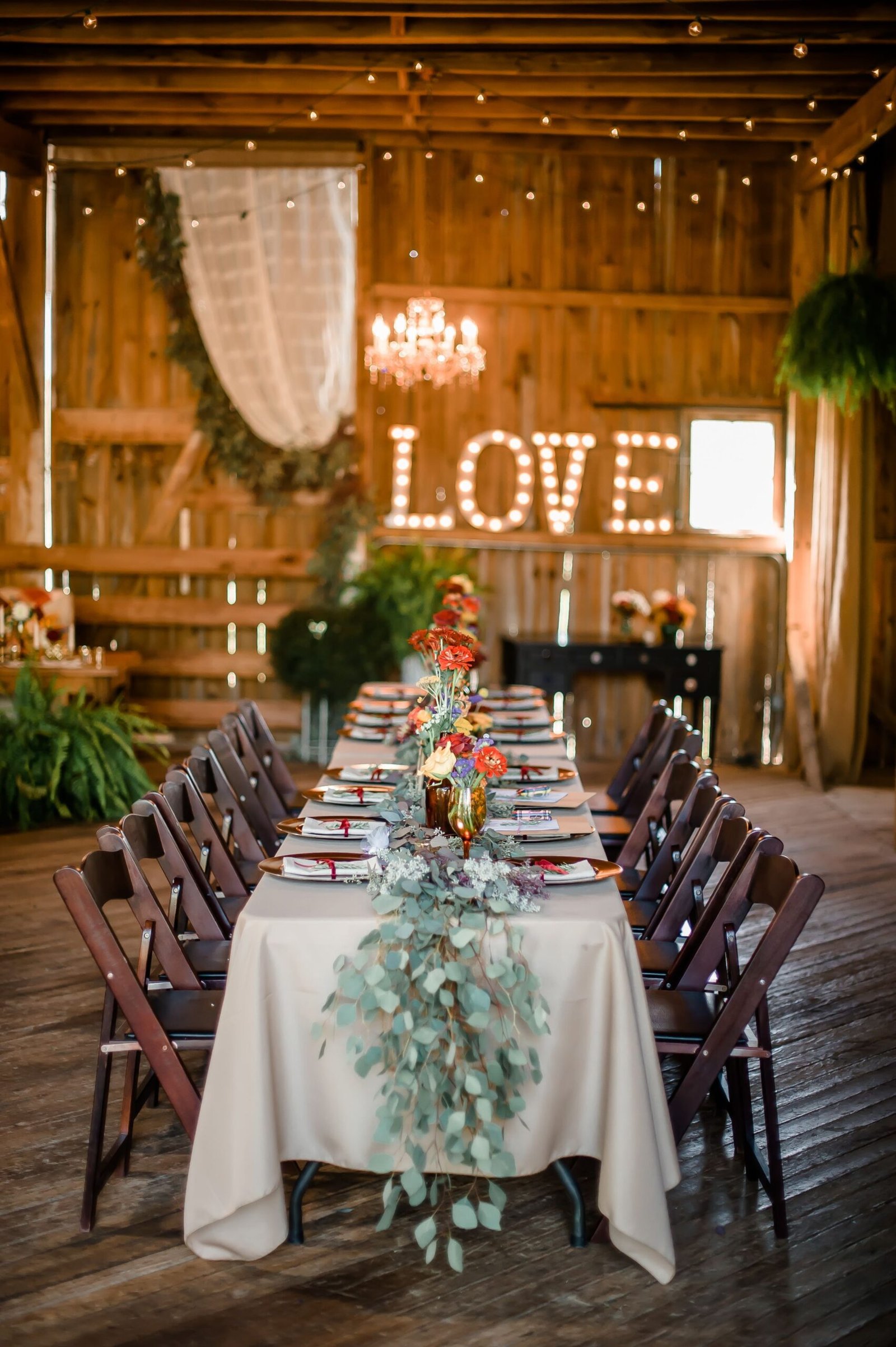 Rustic barn wedding reception with autumn decorations.